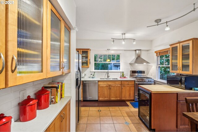 1917 NE Fremont St, Portland, OR 97212 - kitchen with wall chimney exhaust hood, stainless steel appliances, a sink, wine cooler, and backsplash