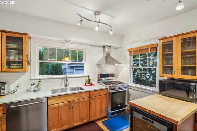 1917 NE Fremont St, Portland, OR 97212 - kitchen with appliances with stainless steel finishes, a sink, wall chimney range hood, tasteful backsplash, and wine cooler