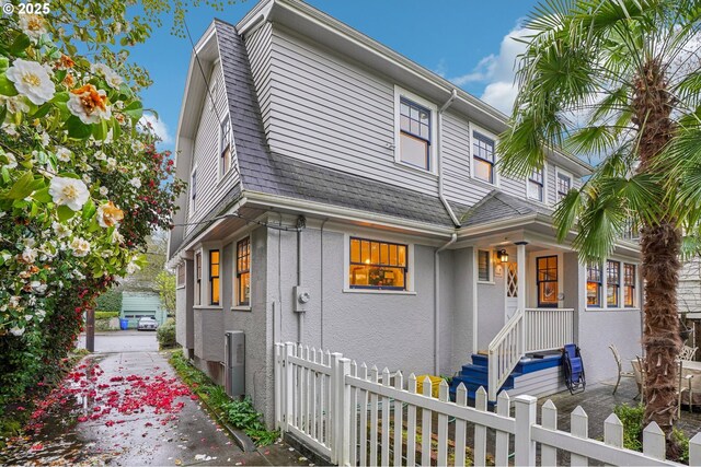 1917 NE Fremont St, Portland, OR 97212 - view of front of home with a fenced front yard, stucco siding, and a shingled roof