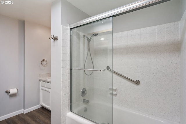 full bathroom with bath / shower combo with glass door, wood finished floors, vanity, and baseboards
