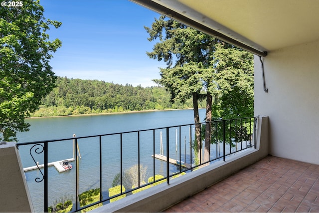 balcony with a water view and a view of trees
