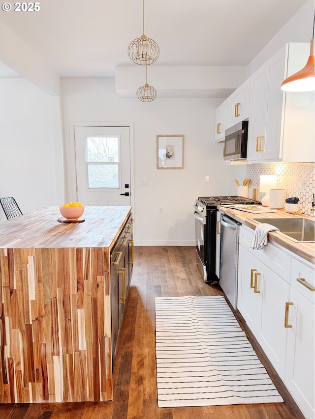 kitchen featuring tasteful backsplash, white cabinetry, stainless steel appliances, and wood finished floors