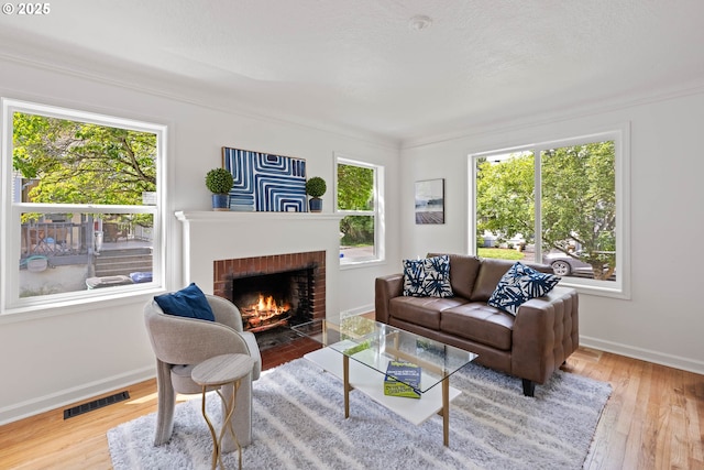 904 NE 78th Ave, Portland, OR 97213 - living area with healthy amount of natural light, a fireplace, wood finished floors, baseboards, and ornamental molding