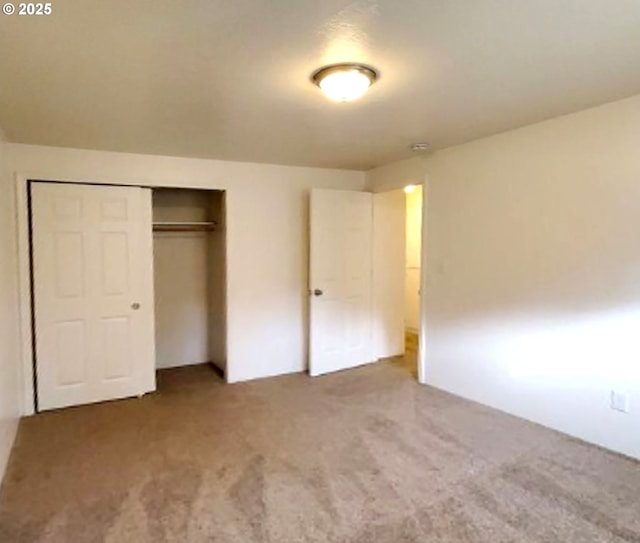 unfurnished bedroom with a closet and carpet flooring