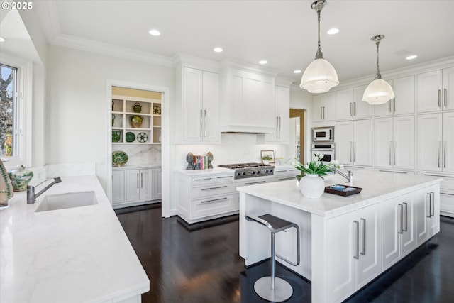 kitchen featuring white cabinetry, sink, pendant lighting, and light stone counters