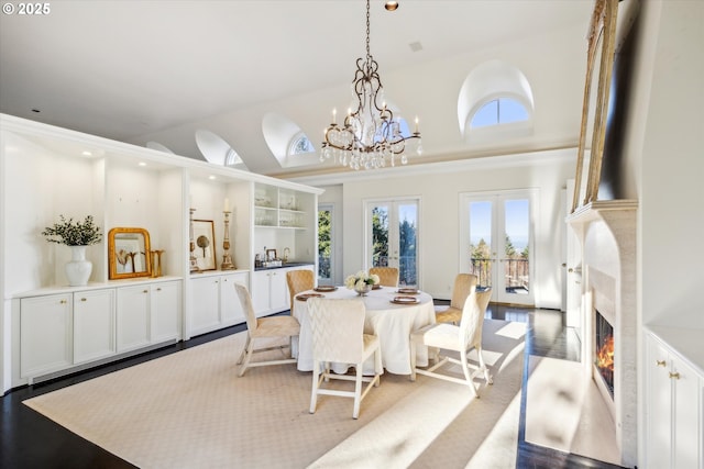 dining room featuring french doors, a notable chandelier, a high ceiling, and hardwood / wood-style flooring