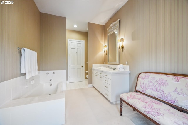 bathroom featuring toilet, vanity, tile patterned flooring, and a relaxing tiled tub