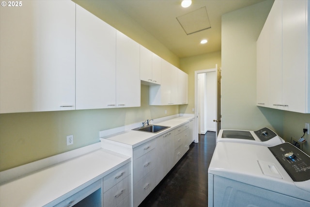 washroom with washing machine and dryer, cabinets, dark wood-type flooring, and sink