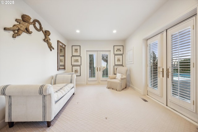 sitting room featuring french doors and carpet flooring