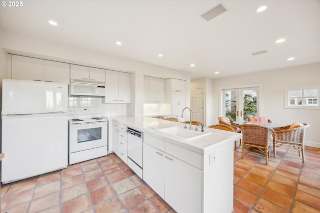 kitchen featuring decorative backsplash, kitchen peninsula, sink, white appliances, and white cabinetry