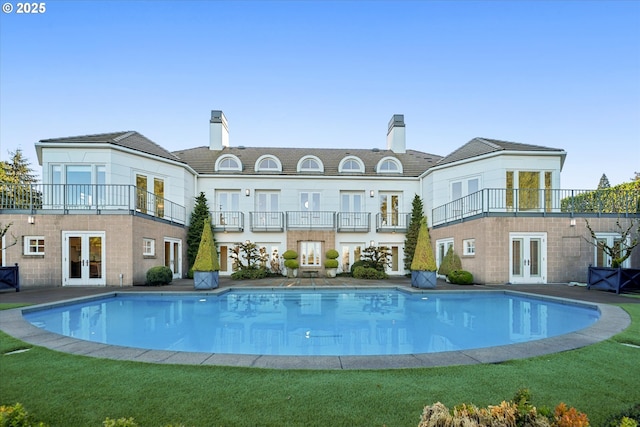 back of house with french doors and a balcony