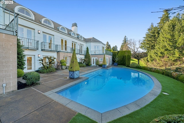 view of swimming pool featuring a patio area and french doors