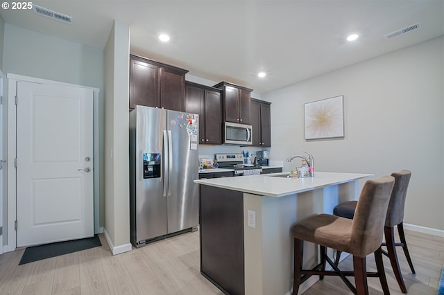 7110 NE 155th Pl, Vancouver, WA 98682 - kitchen featuring visible vents, a sink, dark brown cabinetry, a kitchen island with sink, and appliances with stainless steel finishes