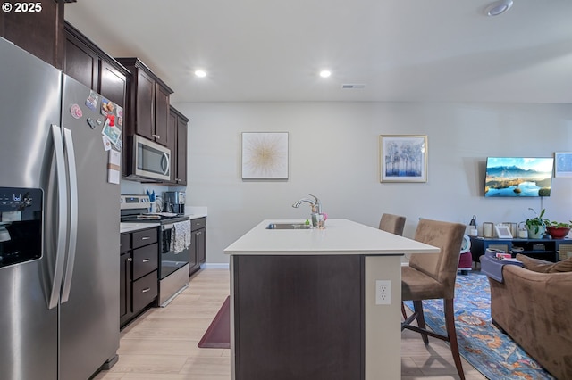 7110 NE 155th Pl, Vancouver, WA 98682 - kitchen featuring a sink, open floor plan, visible vents, a breakfast bar, and appliances with stainless steel finishes