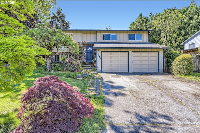 6044 SE Alder Hill Loop, Milwaukie, OR 97267 - bi-level home with driveway, an attached garage, and a chimney