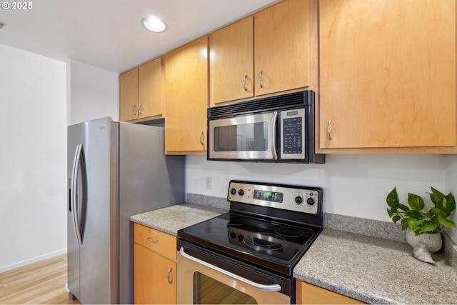 kitchen featuring appliances with stainless steel finishes and light hardwood / wood-style flooring