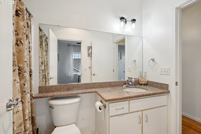 bathroom featuring vanity, hardwood / wood-style flooring, and toilet