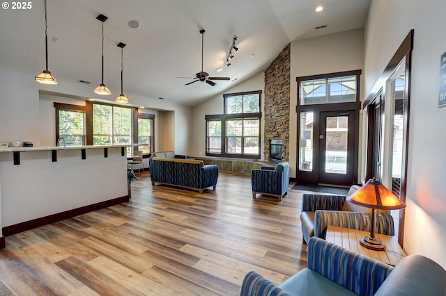 interior space featuring wood-type flooring, high vaulted ceiling, and a fireplace