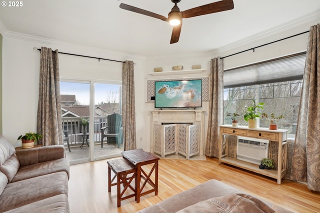 living room with hardwood / wood-style flooring, ornamental molding, an AC wall unit, and ceiling fan