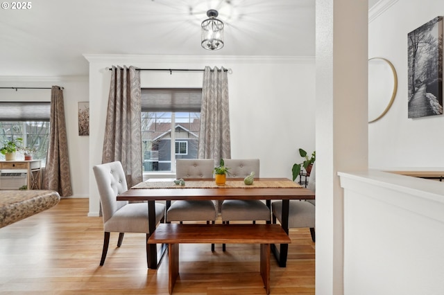 dining room featuring crown molding and light hardwood / wood-style floors