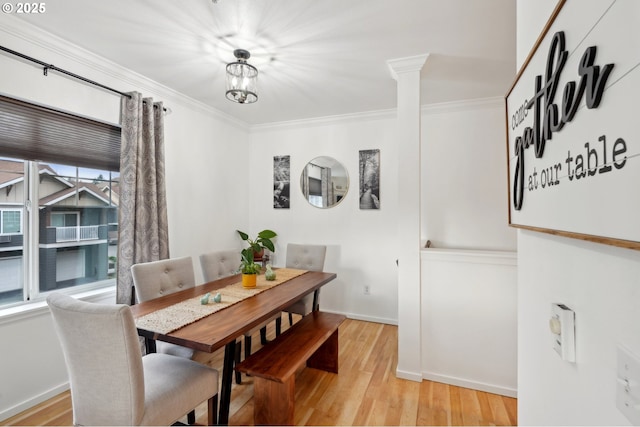 dining area with crown molding, a wealth of natural light, light hardwood / wood-style floors, and ornate columns