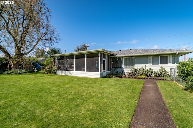 view of front of property featuring a front lawn and a sunroom