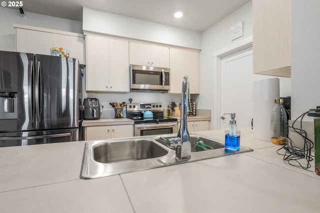 kitchen featuring appliances with stainless steel finishes and cream cabinetry