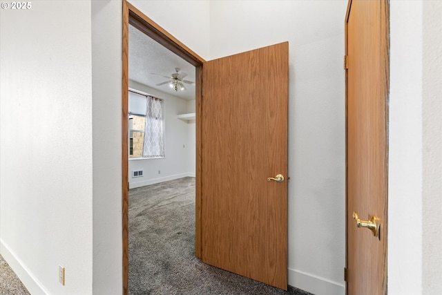 hallway featuring dark colored carpet