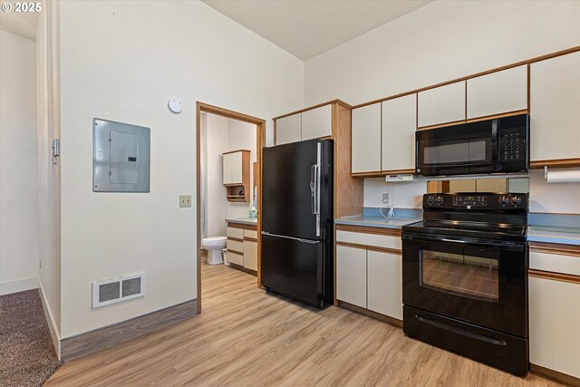 kitchen with white cabinetry, hanging light fixtures, light hardwood / wood-style flooring, and electric panel