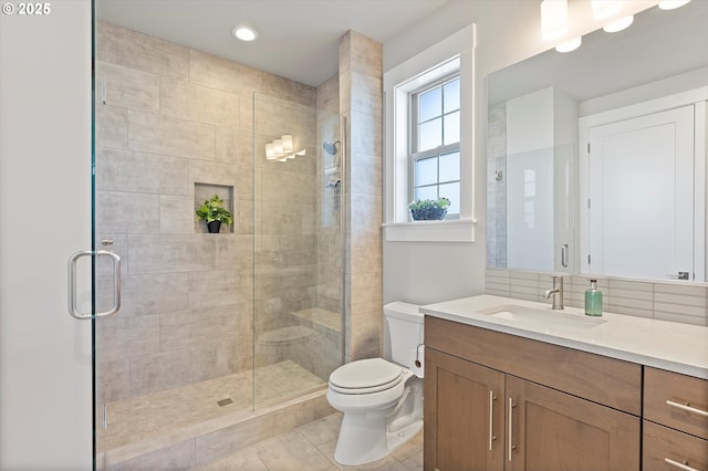 full bath with a stall shower, backsplash, toilet, and vanity