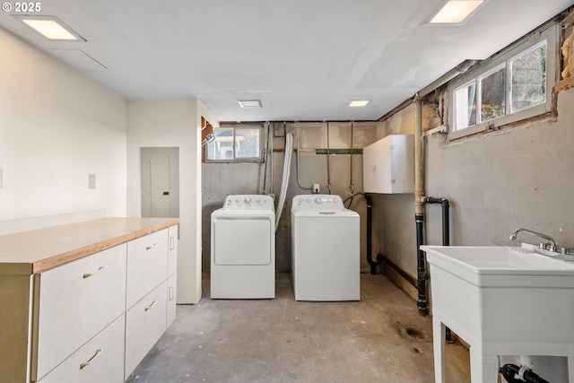 clothes washing area featuring cabinet space, a sink, and independent washer and dryer