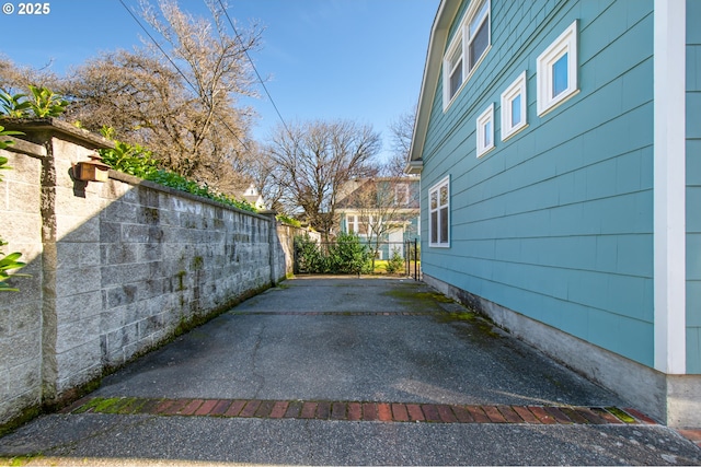 view of property exterior with fence and a patio