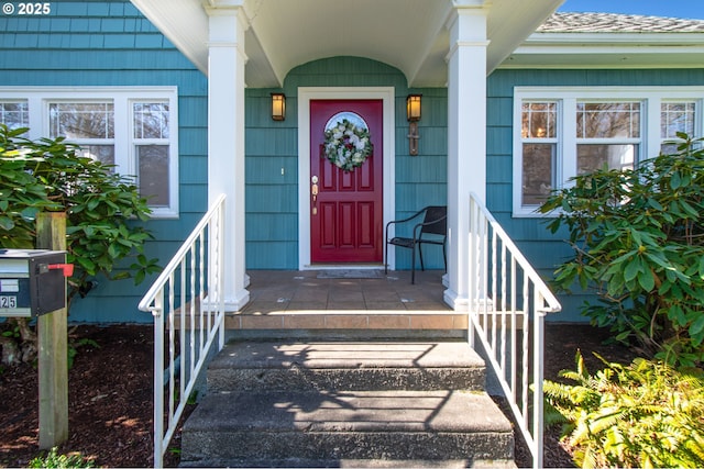 doorway to property featuring a shingled roof