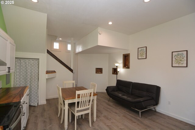 dining area featuring baseboards, light wood-type flooring, and recessed lighting