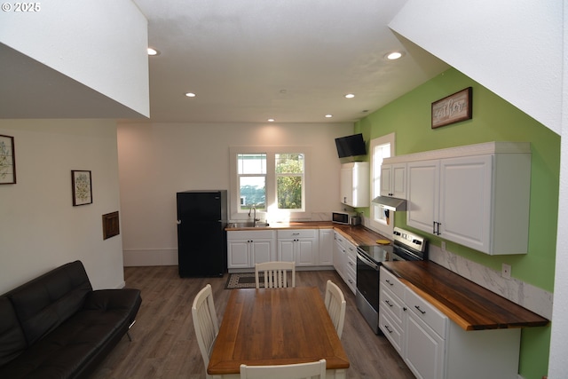 kitchen with wood counters, appliances with stainless steel finishes, dark wood-style flooring, white cabinetry, and a sink