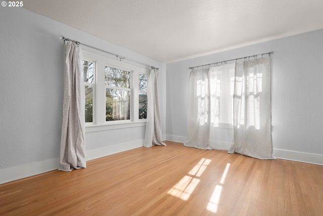 spare room with wood finished floors and baseboards