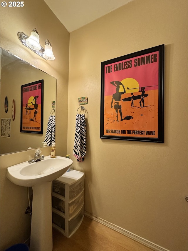 bathroom with wood finished floors and baseboards