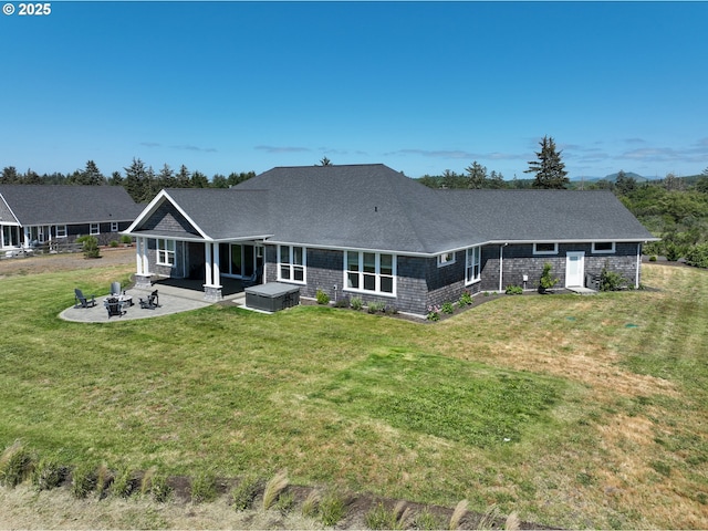 rear view of house featuring a patio, a yard, and a fire pit