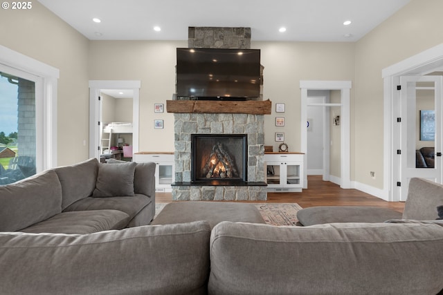 living room featuring hardwood / wood-style flooring and a stone fireplace