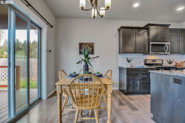 kitchen featuring hanging light fixtures, light hardwood / wood-style flooring, decorative backsplash, dark brown cabinets, and stainless steel appliances