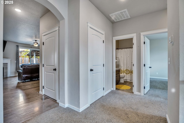 hallway with carpet and a textured ceiling