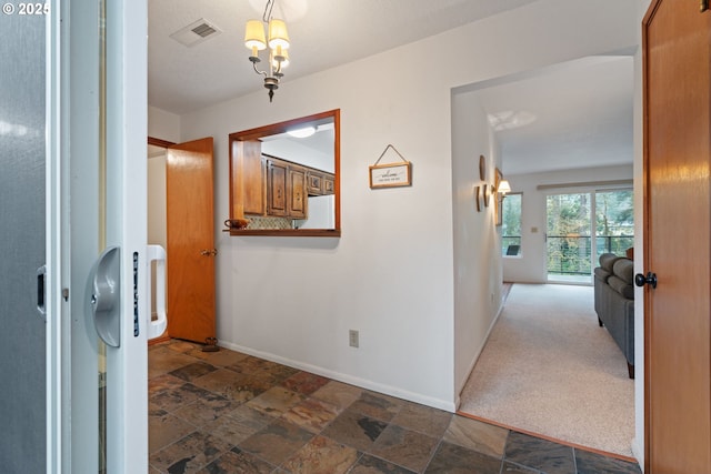 18308 NE Cole Witter Rd, Battle Ground, WA 98604 - corridor featuring baseboards, dark stone finish floors, and a chandelier