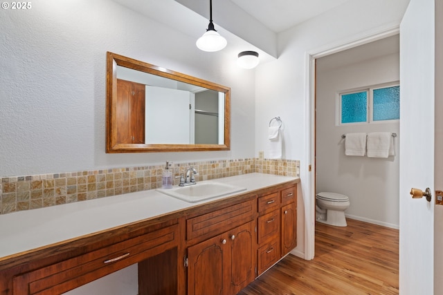 18308 NE Cole Witter Rd, Battle Ground, WA 98604 - bathroom featuring wood finished floors, toilet, decorative backsplash, vanity, and baseboards
