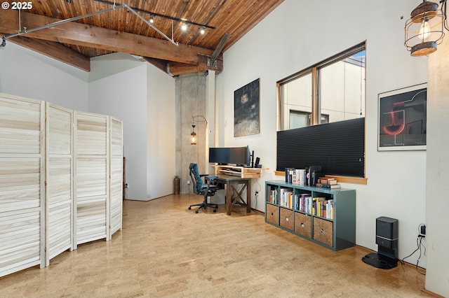 office space featuring beamed ceiling, wood ceiling, a towering ceiling, and track lighting