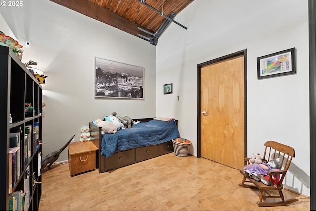 bedroom featuring tile patterned floors, beamed ceiling, wood ceiling, and a towering ceiling