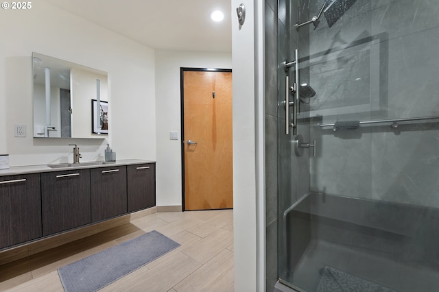 bathroom featuring wood finish floors, vanity, and a shower stall