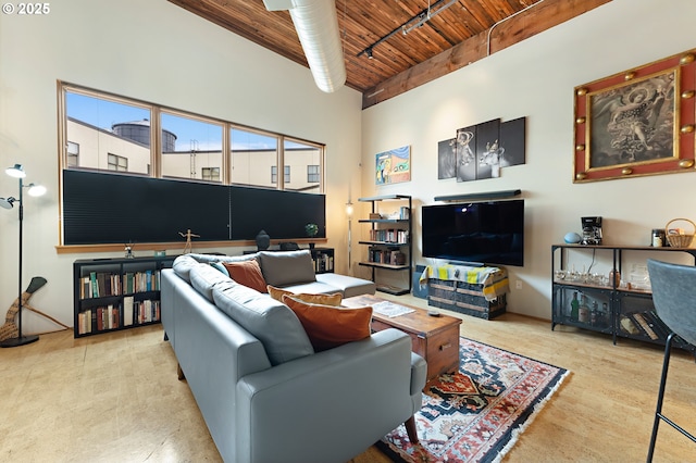 living area featuring a high ceiling, rail lighting, and wood ceiling