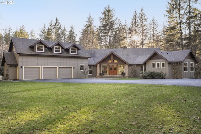 view of front facade featuring driveway, board and batten siding, and a front yard