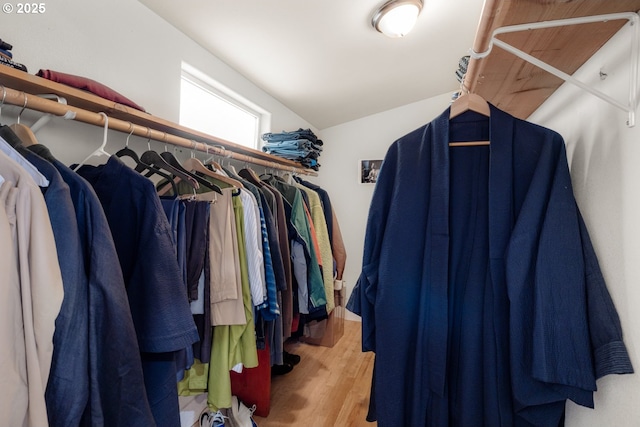spacious closet with lofted ceiling and wood finished floors