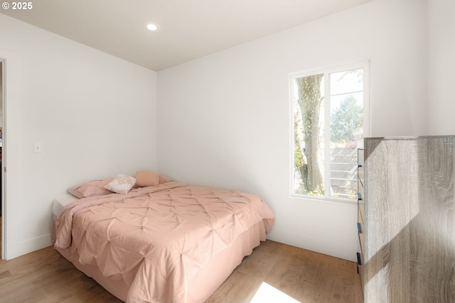 bedroom featuring wood finished floors, recessed lighting, and multiple windows